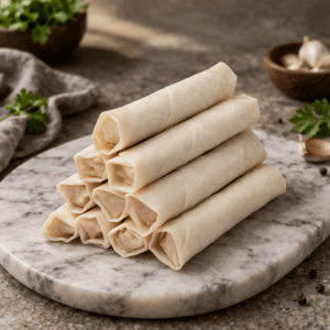 Four fresh handmade spring rolls placed in a straight line on a clean white surface — www.paknpure.com