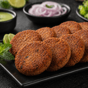Premium beef shami kabab served on a black plate with crispy texture, mint leaves, and dipping sauce.
